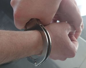 Na zdjęciu kajdanki na rękach.