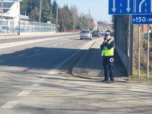 Na zdjęciu policjantka trzymająca urządzenie do pomiaru prędkości.
