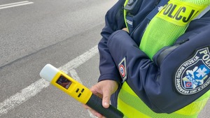 Na zdjęciu policjant trzymający urządzenie do badania stanu trzeźwości.