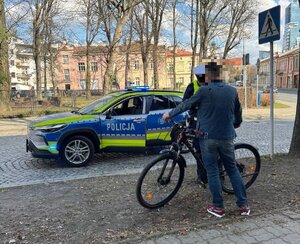 Na zdjęciu policjant kontrolujący rowerzystę.