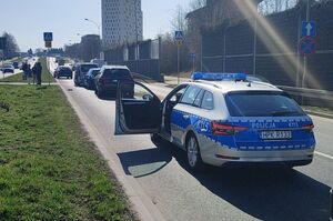 Na zdjęciu policyjny radiowóz, przed nim pojazdy.