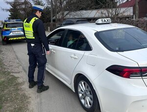 Na zdjęciu policjantka kontrolująca taksówkę.