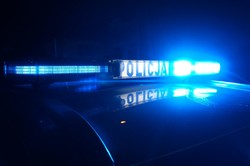 Belka policyjnego radiowozu z napisem Policja, pora nocna