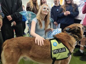 Na zdjęciu pies policyjny i uczestniczka wydarzenia.
