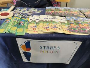 Na zdjęciu stolik profilaktyczny i gadżety policyjne.