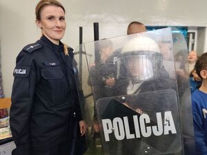 Na zdjęciu policjantka wraz z dzieckiem ubranym w sprzęt PZ.