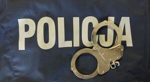 Na zdjeciu napis policja, na nim leżą policyjne kajdanki.