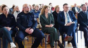 Na zdjęciu policjant wraz z uczestnikami warsztatów.