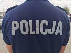 Na zdjeciu odwrócony tyłom policjant z napisem policja na plecach.