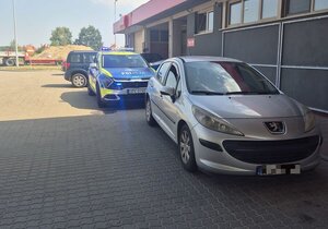 Zdjęcie przedstawia radiowóz Policyjny oraz zatrzymany pojazd sprawcy